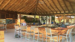 A restaurant with a rustic wooden interior, including a bar area with stools and a menu board. - Your Perfect Beachfront Condo in Paradise - Sapphire Beach (Smith Bay)