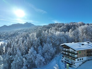 A hotel with a view of snow-covered trees and mountains. - Naturhotel Waldesruhe (Oberstdorf)