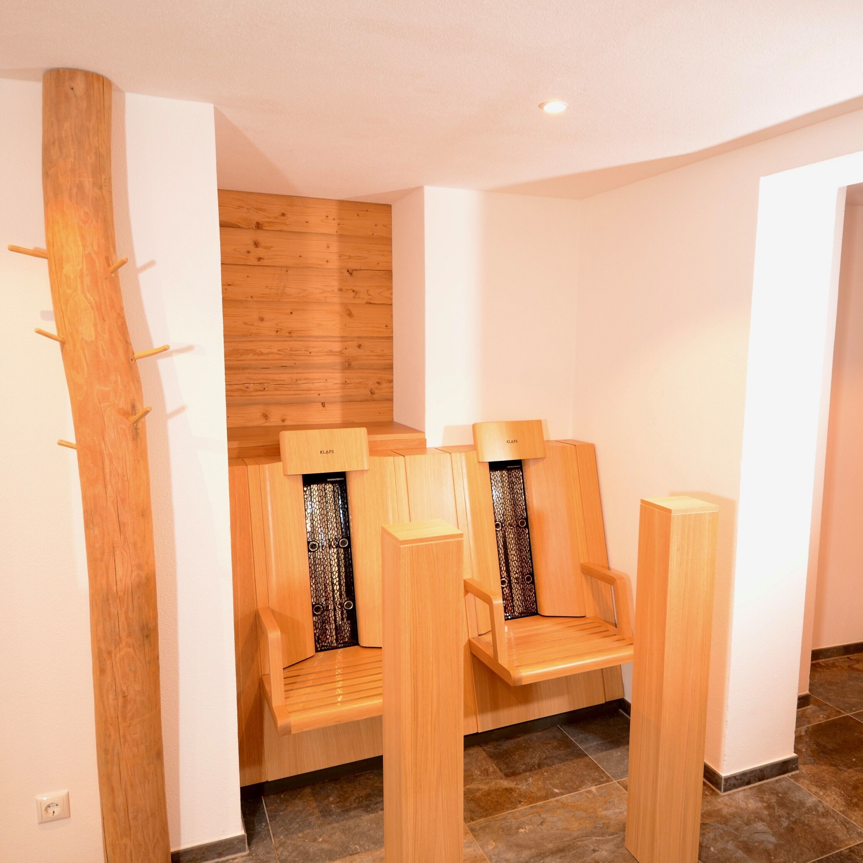A modern bathroom with wooden benches and a wooden wall panel.