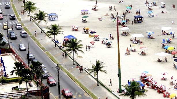 Een strand met veel parasols en mensen.