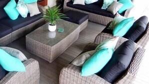 A seating area with wicker sofas and a central coffee table, featuring a potted plant. - "Riverbend Suites" BYRON Hinterland Retreat (Rosebank)