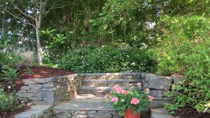 A stone staircase leading up to a garden area with a potted plant. - Stunning hse-AC, heatd Pool, spa, fire pit, private acre, walk/free bus to town (Nantucket)