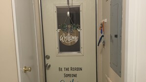 Eine Tür mit einem 'Welcome'-Schild und einer motivierenden Botschaft.