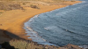 Ein Strand mit sandigem Ufer und Wellen.