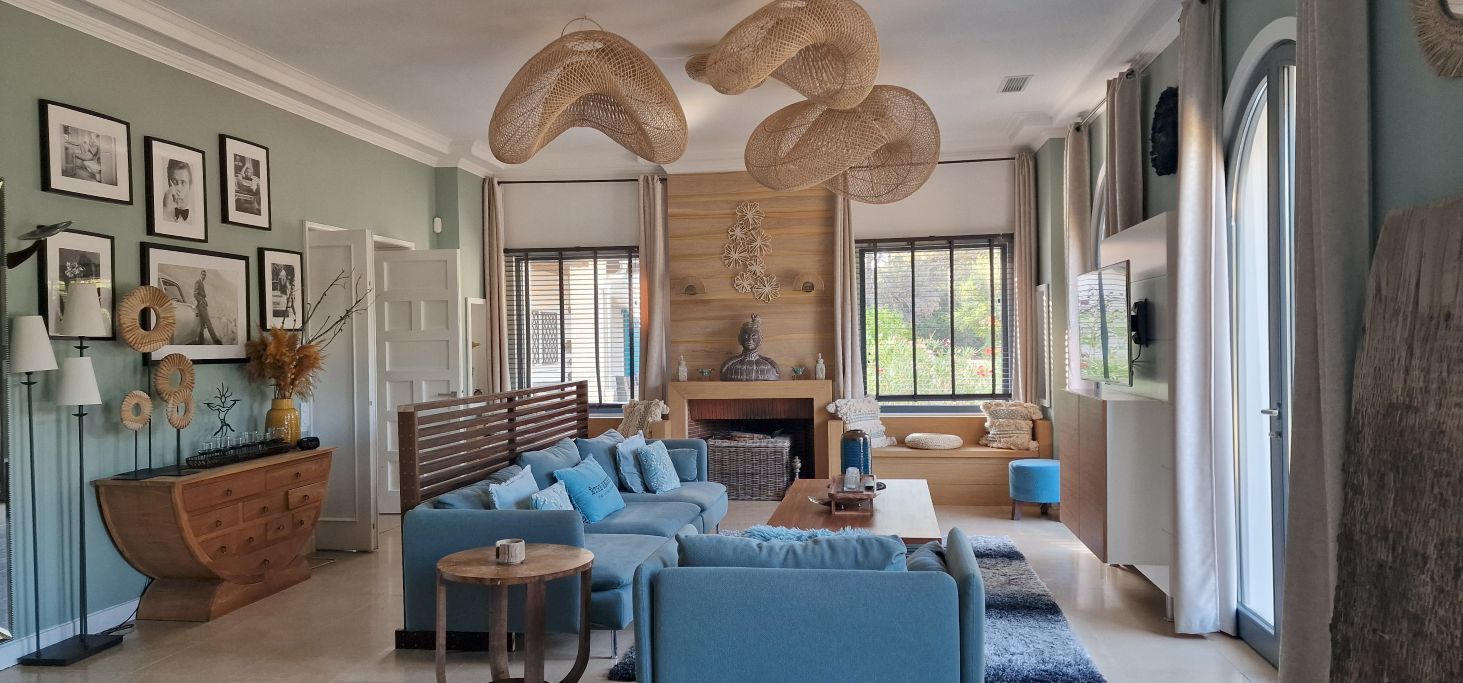 A living room with a sofa set, a wooden cabinet, and a fireplace.