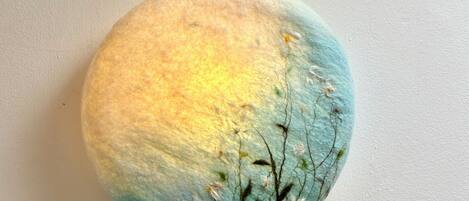 A round object with a textured surface and a gradient of colors from yellow to blue.