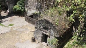 Un bâtiment en pierre avec une petite entrée et des marches menant à celle-ci.