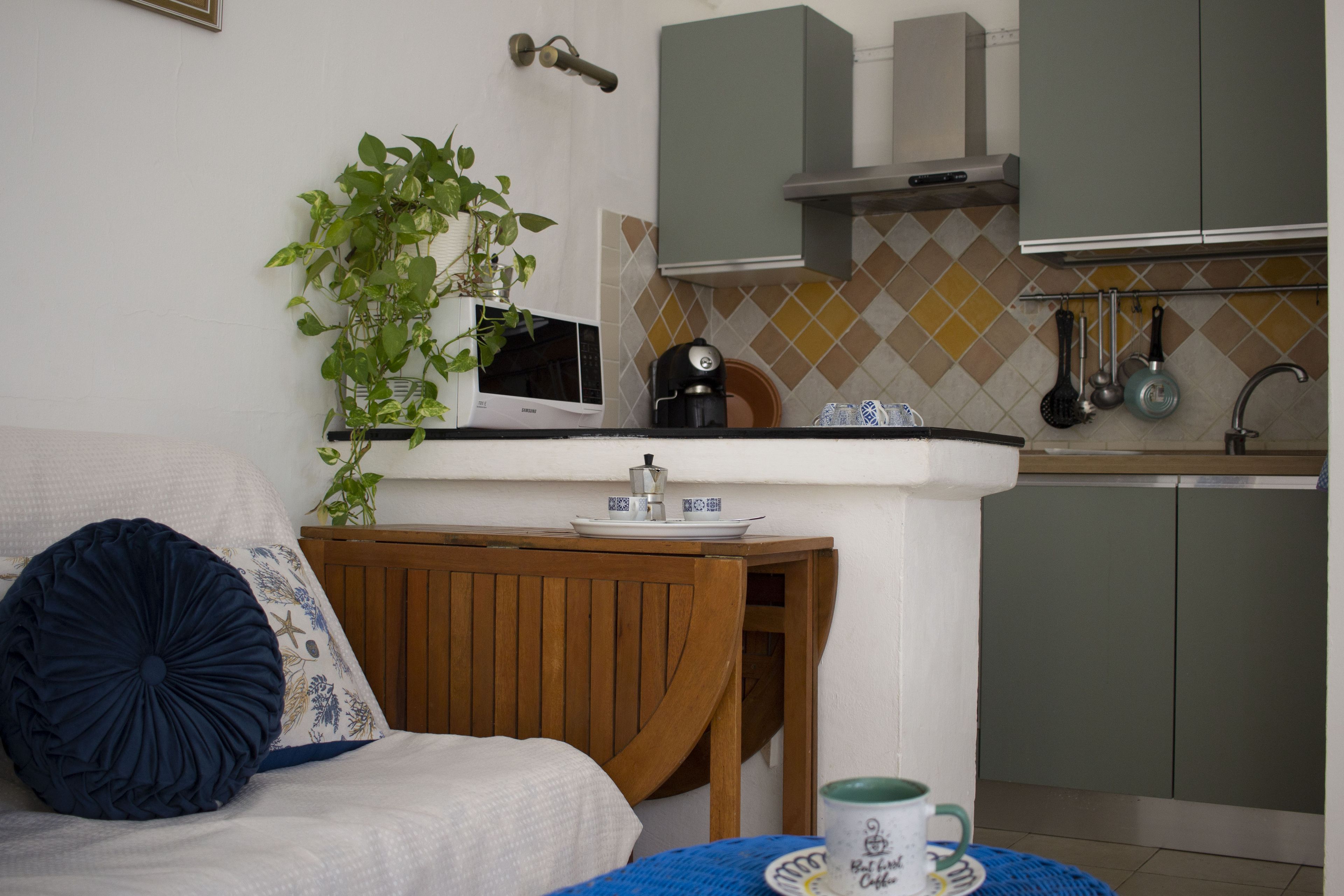 A compact living space with a kitchenette, a dining area, and a seating area with a sofa and a coffee table.