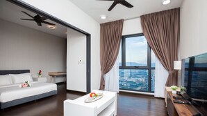 A modern hotel room with a bed, a white coffee table, a TV, and a large window with curtains.