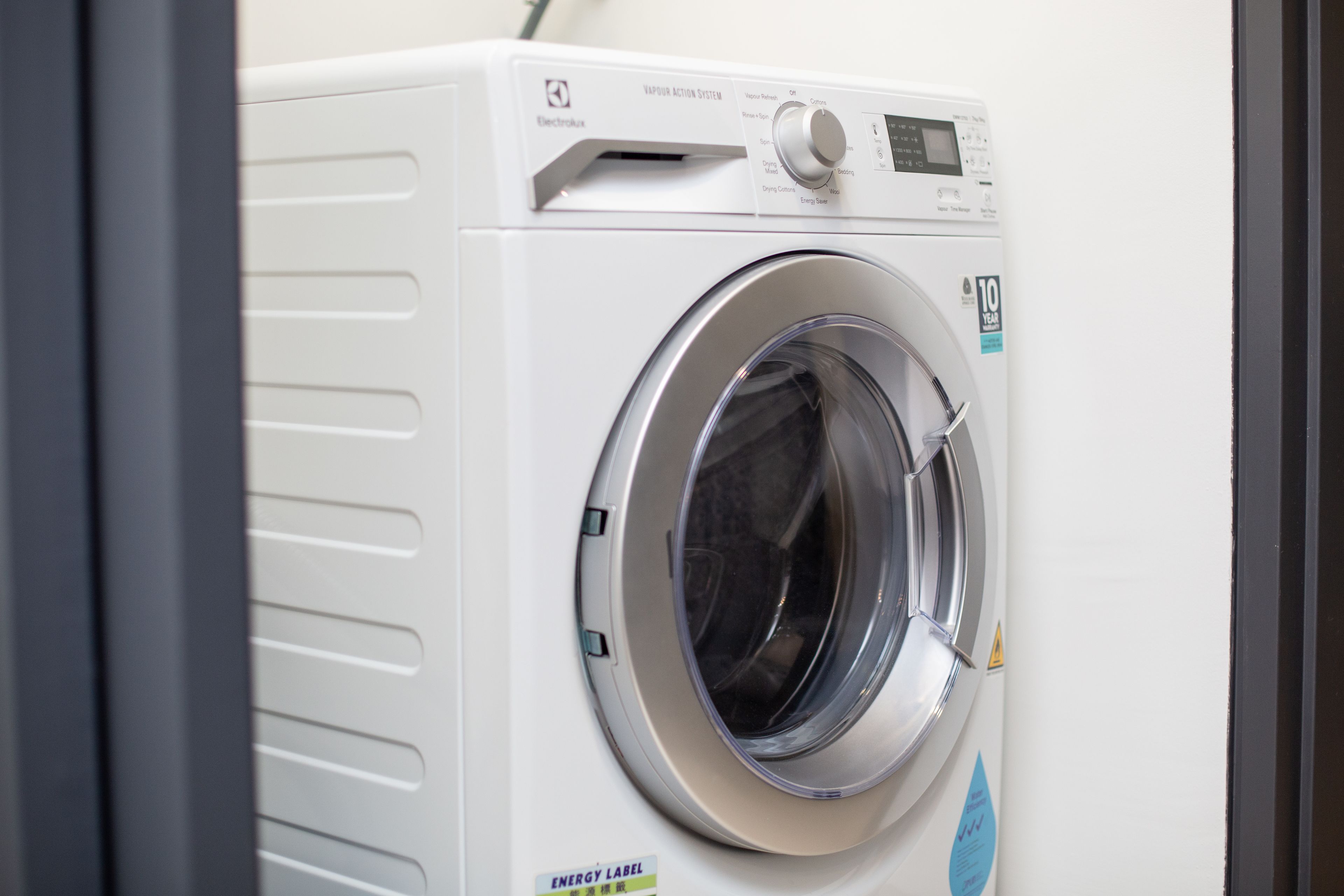 A front view of a white washing machine with a digital display and control panel.