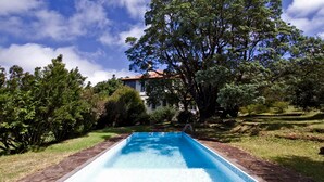 A rectangular swimming pool with a clear blue water surface, surrounded by a brick border.