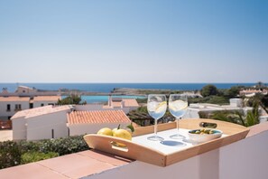 Eine Terrasse mit einem Tablett Zitronen, zwei Gläsern eines blauen Getränks und einer Schale Oliven.