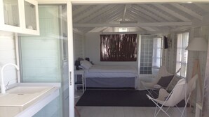 A room with a bed, a chair, a small table, and a sink. - Beautiful new bungalow with views. (Le vauclin)