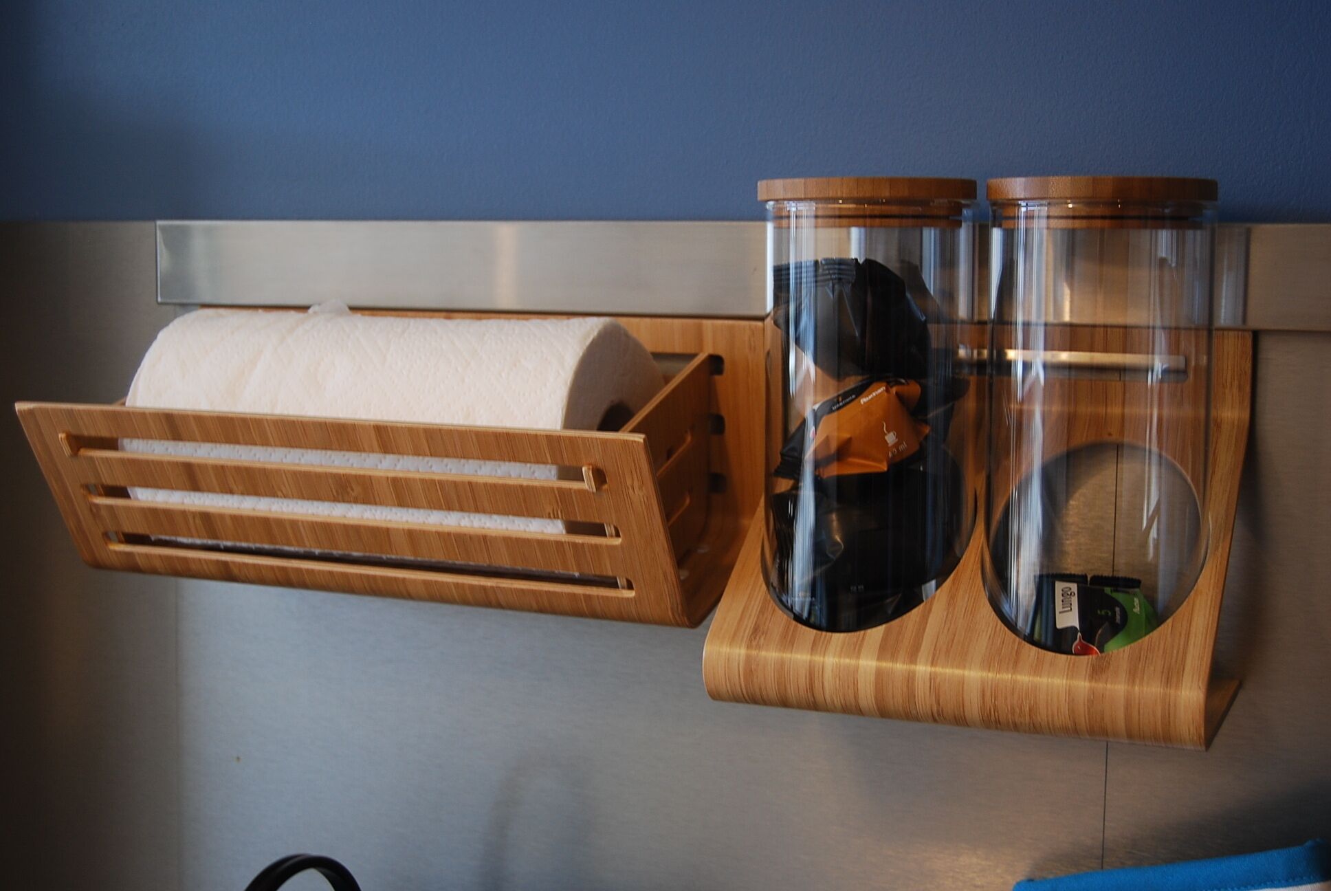 Een houten plank met een toiletpapierhouder en twee glazen potten met deksels.