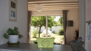 Een kamer met uitzicht op een tuin, een bloempot, een groene doos en een stenen vijzel.