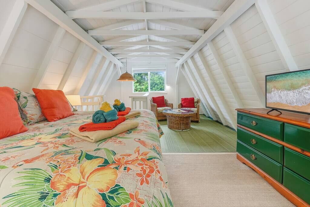 Ein Schlafzimmer mit einem Bett, einem Schminktisch, einem Sessel und einem Fernseher.