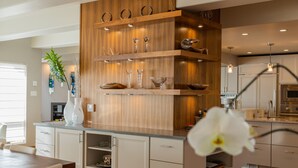 A modern kitchen with wooden cabinetry, a central island, and pendant lighting.