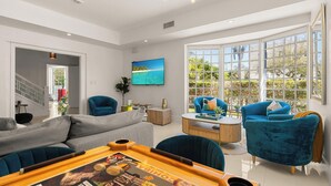 A modern living room with a grey sofa, blue armchairs, and a wooden coffee table. - Villa Diamond in South Beach (Miami Beach)