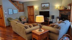 A living room with a sofa set, a TV, a fireplace, and a staircase. - Beautiful Pristine O'brien Lake Home in Crosslake MN, Sleeps 10 (Crosslake)