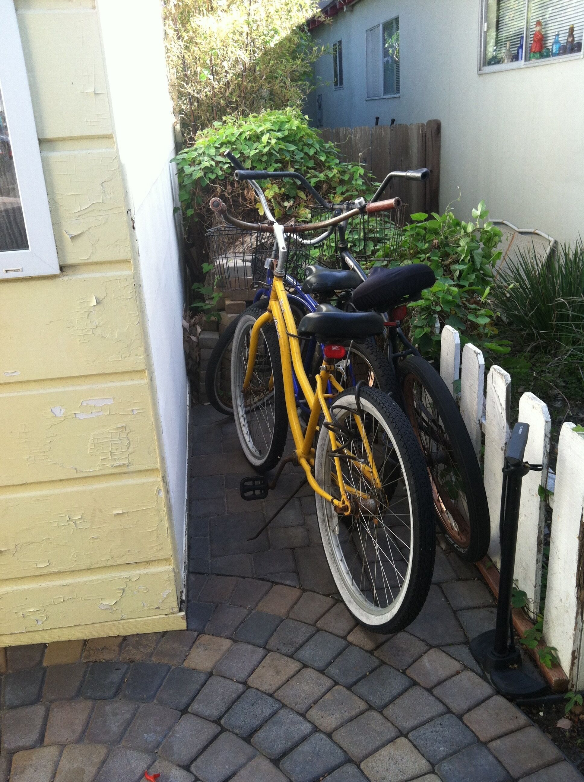 Un edificio amarillo con una puerta y un ventanal. Una bicicleta está estacionada al lado del edificio.