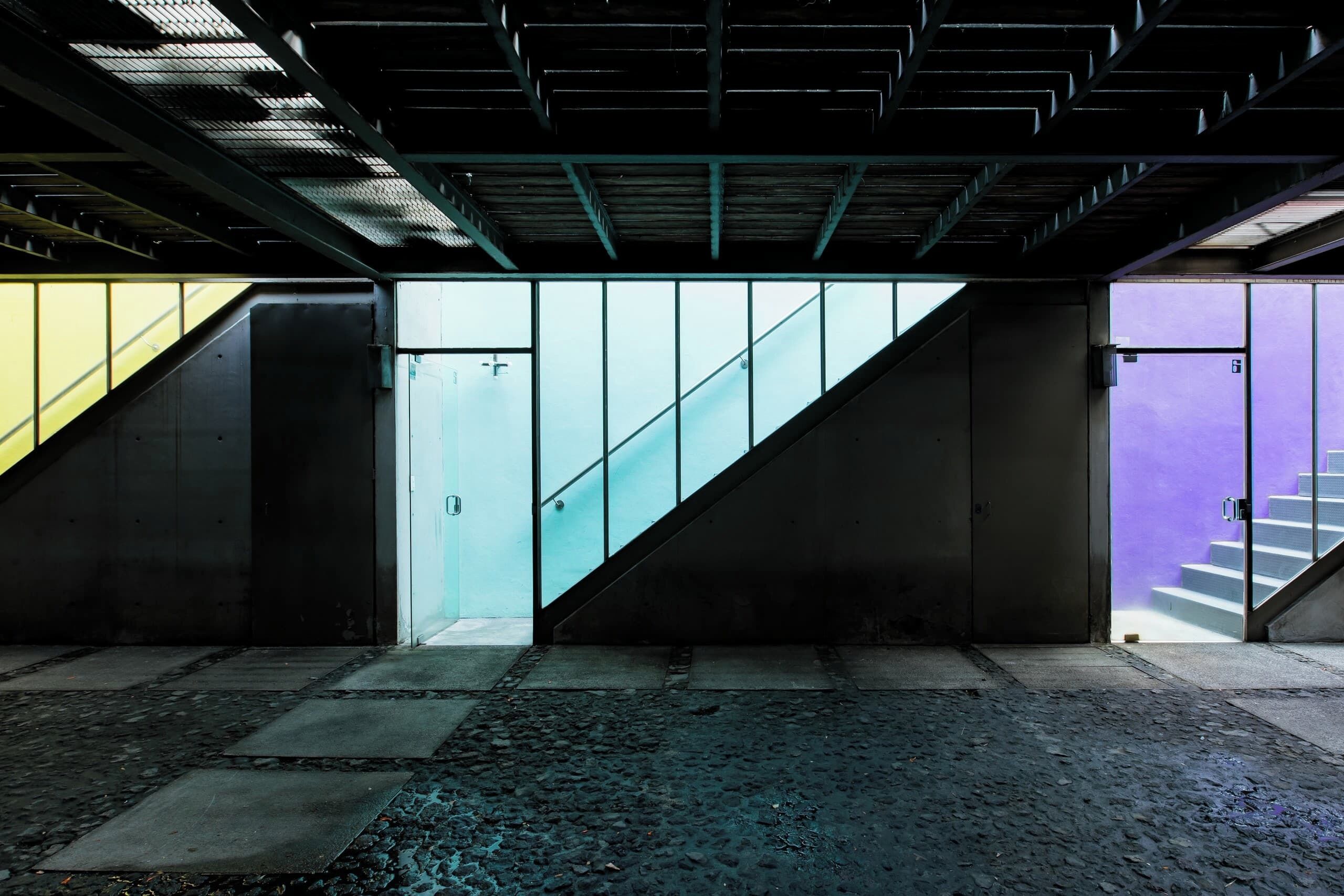 An indoor staircase with a metal staircase railing and a glass wall.