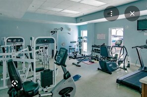 A gym with exercise equipment, a treadmill, and a weight bench.