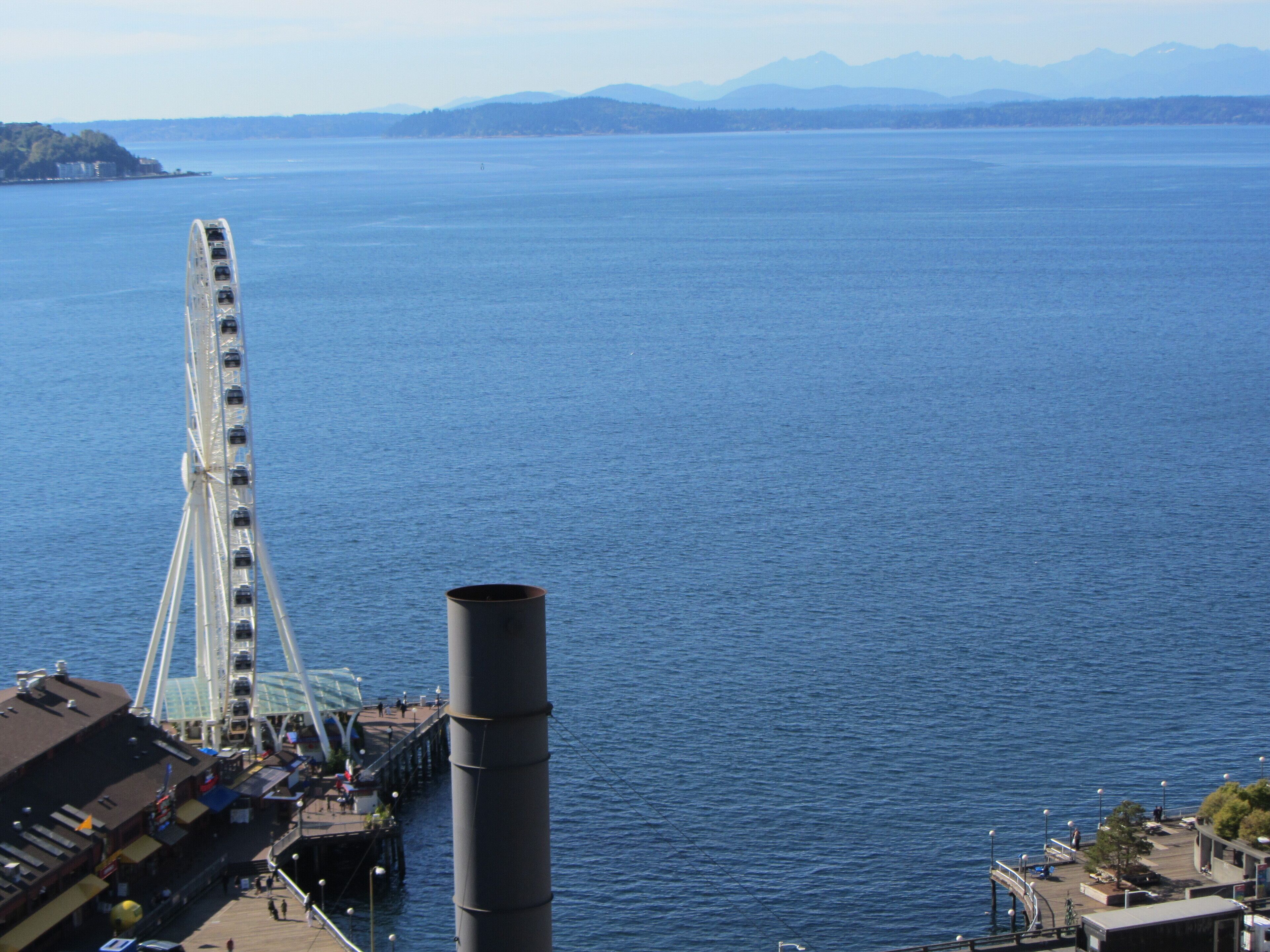 Une vue sur le front de mer, avec une grande roue et une haute cheminée.