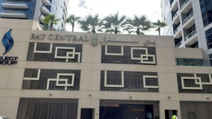 Un edificio de varios pisos con la señalización 'BAY CENTRAL' y 'ELECT GROUP', que indica un hotel o complejo de negocios.