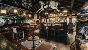 Un coin bar rustique avec des meubles en bois, une sculpture de cheval et un mur en pierre.