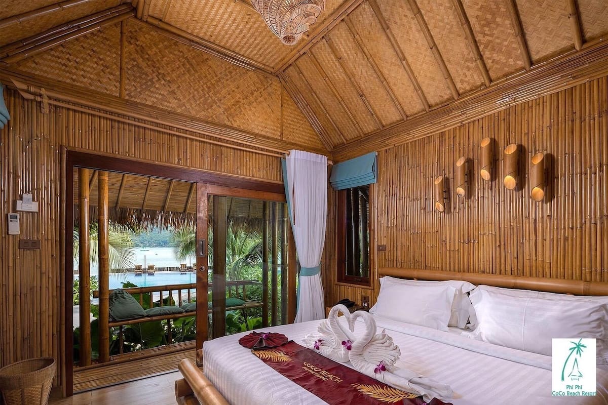 Een houten kamer met een bed, een raam en uitzicht op een zwembad.