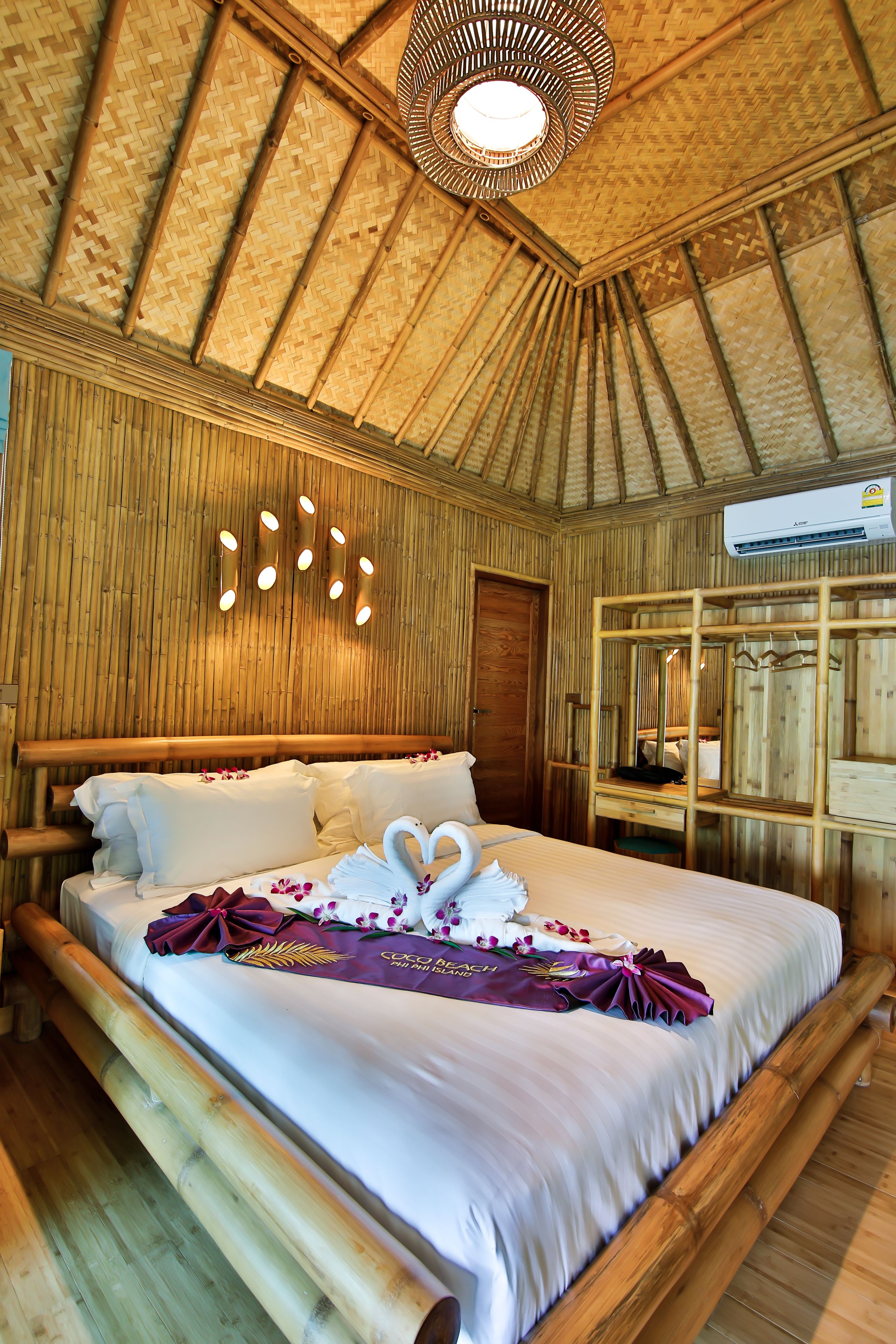 Ein Zimmer mit einem Bett, einer Wandklimaanlage und einem Deckenventilator.