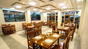 A dining area with multiple wooden tables and chairs, arranged in a spacious layout. - Five One Star Hotel (Nyaungshwe)