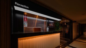 A reception area with a modern design, featuring a reception desk, a digital screen, and a sign indicating the location. - HOTEL BAMBOO GARDEN Shin-Yokohama - Adults Only (Yokohama)
