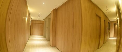 A corridor with wooden panel walls and a light-colored floor.
