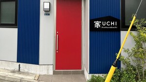 A modern building with a red door, a blue vertical panel, and a sign reading "UCHI Asakusa". - UCHI Asakusabashi (Tokyo)