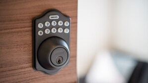 A modern electronic keypad lock on a wooden door. - UCHI Asakusabashi (Tokyo)