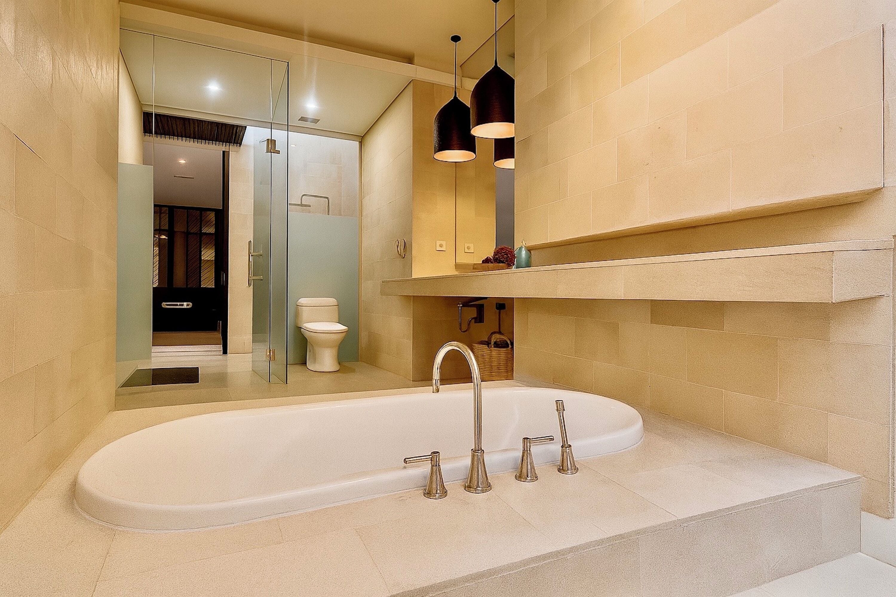 A modern bathroom with a freestanding bathtub, a glass shower enclosure, and a vanity with a mirror and shelf.