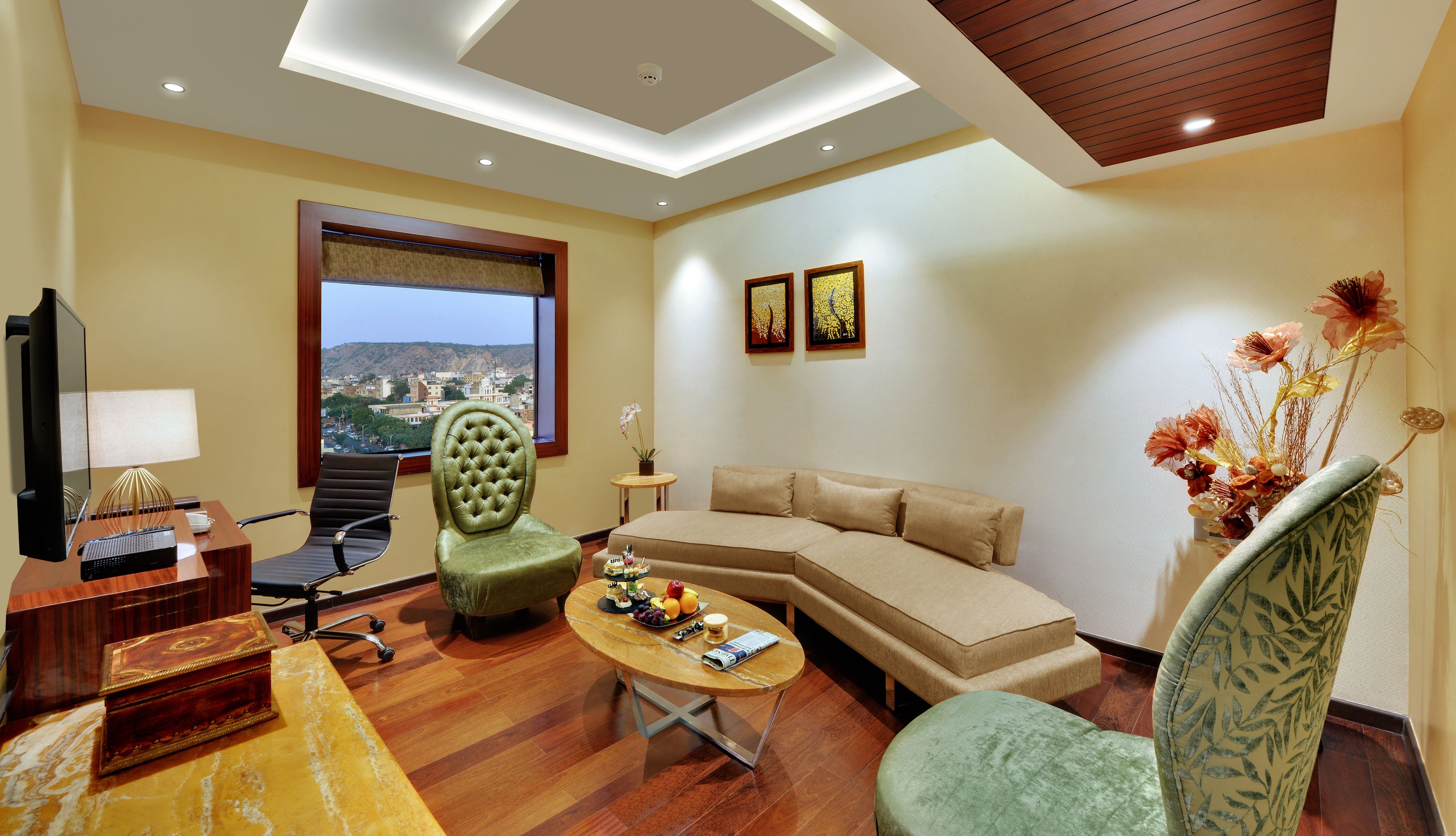 A modern living room with a sofa, armchairs, a coffee table, and a TV.