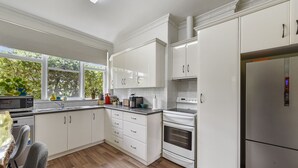 A modern kitchen with white cabinetry, a built-in oven, and a stainless steel refrigerator. - Comfort on Crouch- Enjoy this beautiful house right in CBD.  (Mount Gambier)