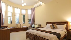 A bedroom with a large bed, a desk, and a window with curtains. - Summer Time B&B (Magong)
