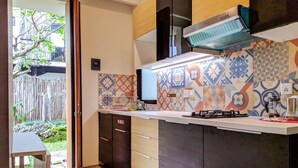 Una cocina moderna con horno empotrado, microondas y cafetera.