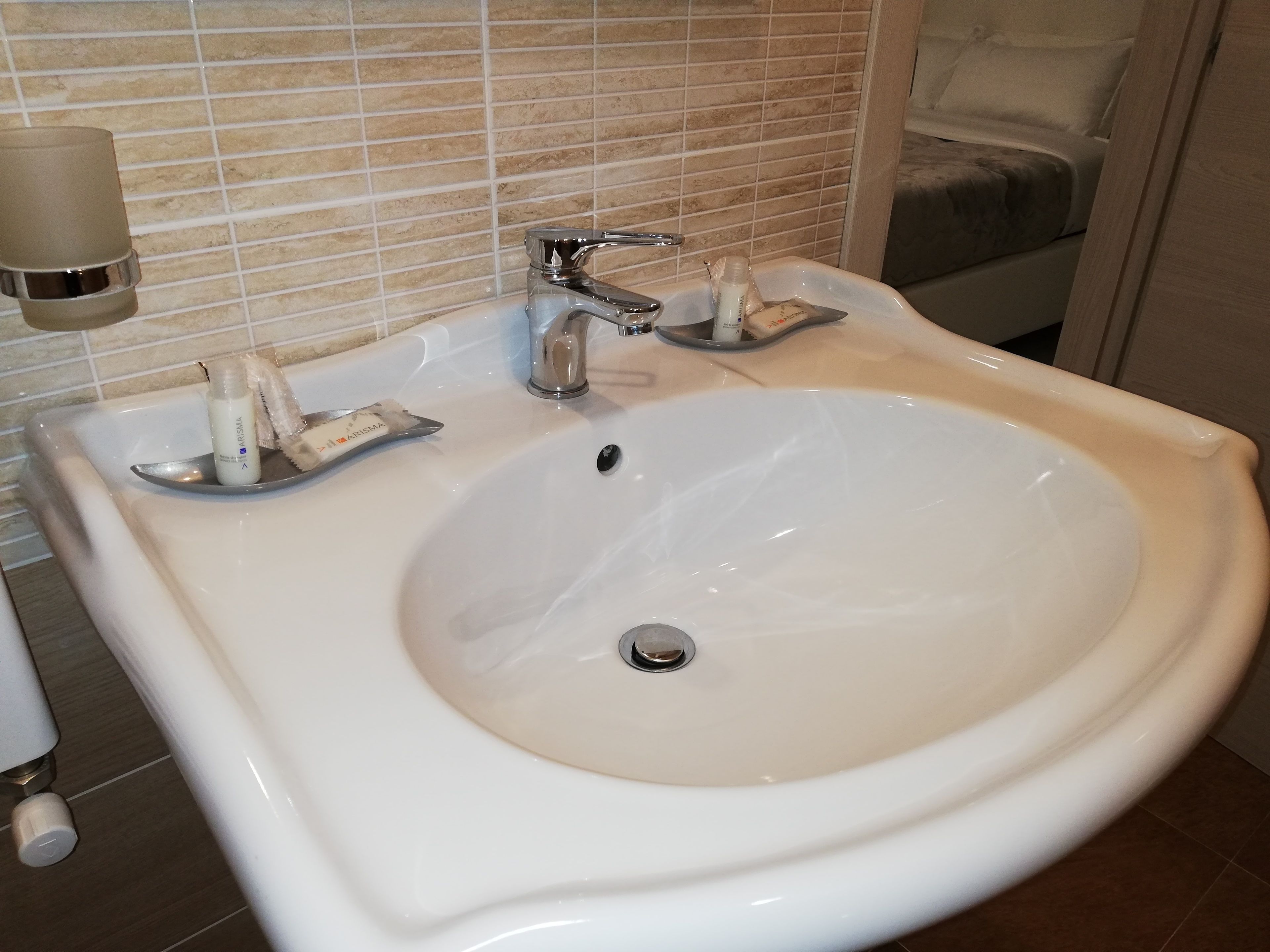 A white bathroom sink with a single faucet and a soap dispenser.