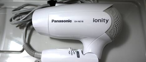 Un secador de pelo Panasonic ionity con cable, sobre una superficie blanca.
