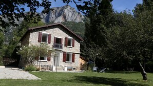 A two-story stone house with a balcony, surrounded by a well-maintained lawn and trees. - Villa Victoire - Charming house with garden - 10 people - 5 bedrooms - 3 bathrooms - 2 WCs (Aulos)