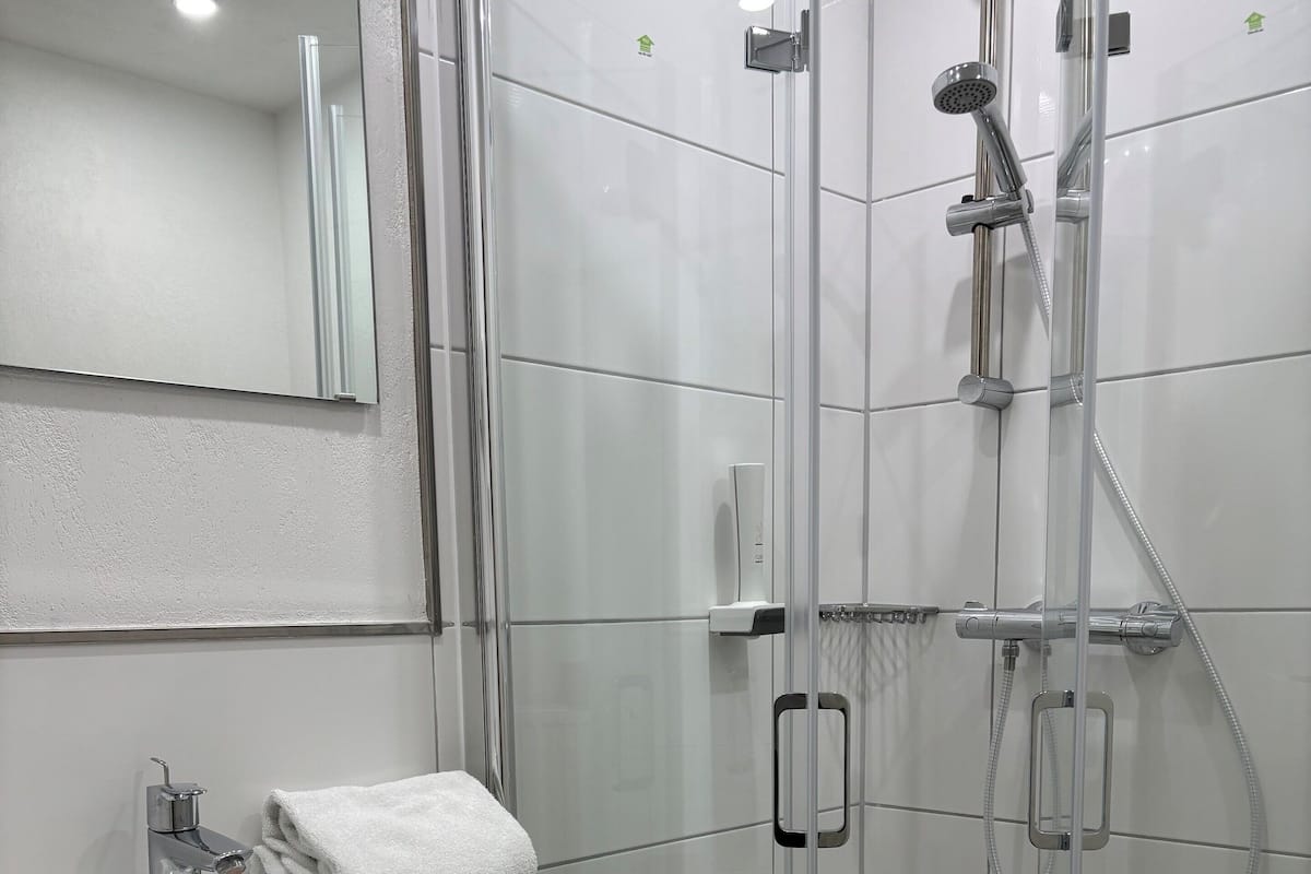 Chuveiro, secador de cabelo, toalhas de banho, sabonete
