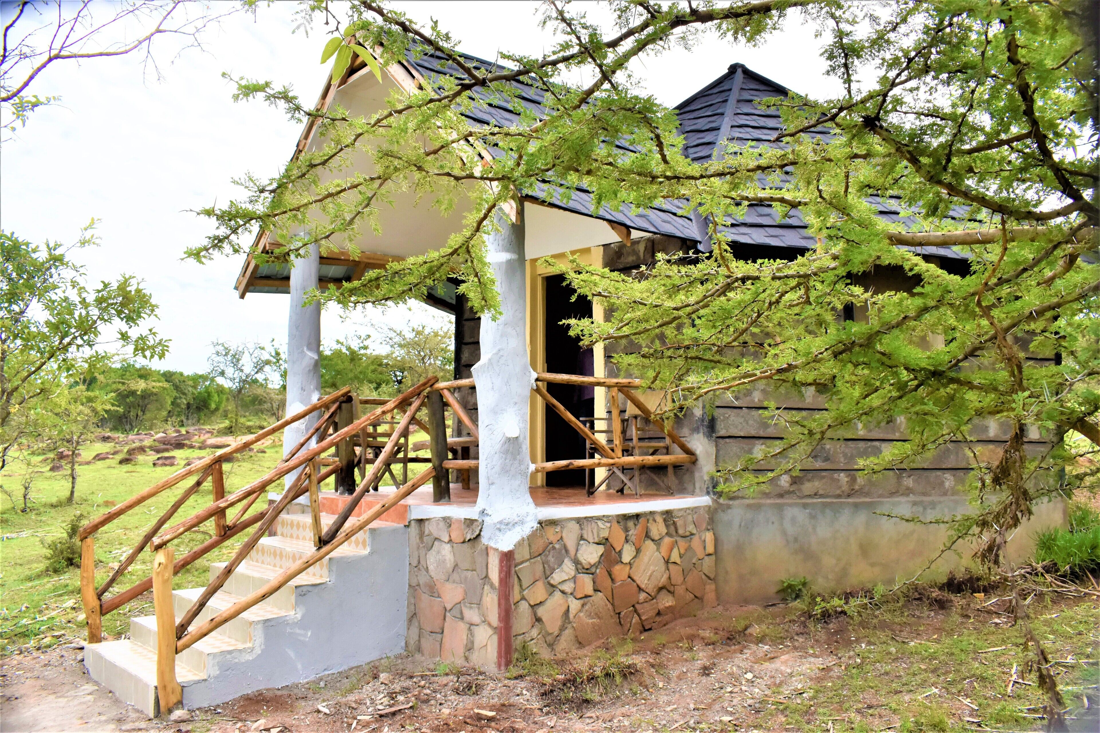 A wooden staircase leading to a covered porch with a stone wall.