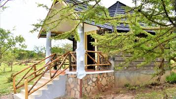 A wooden staircase leading to a covered porch with a stone wall.