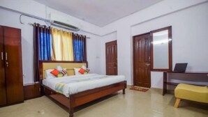 Ein Schlafzimmer mit einem hölzernen Bett, einem Schreibtisch, einem Stuhl und einem Kleiderschrank.