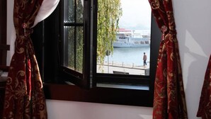 Habitación con ventana que da a la zona costera, incluyendo un muelle y una persona caminando.
