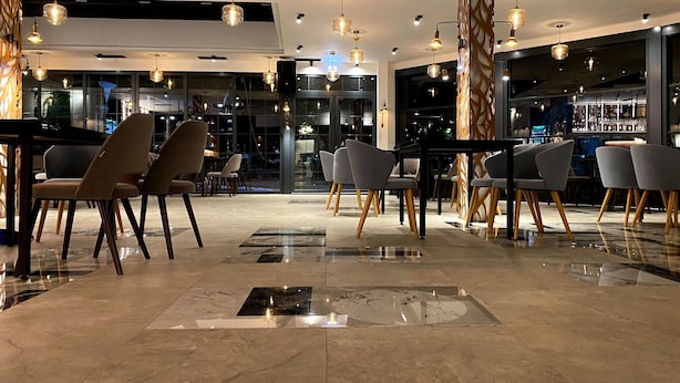 Un bar moderno con diversas opciones de asientos e iluminación colgante.